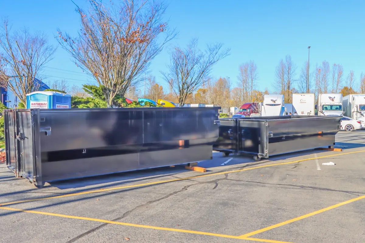 Professional dumpster rental service with roll-off container on residential driveway in Anniston